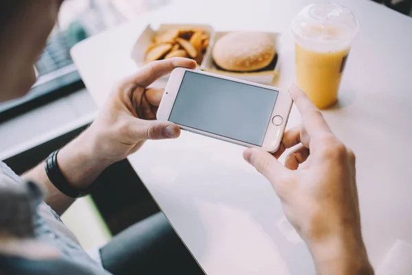 Genç adamın cep telefonu tutan el