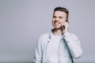 Beyaz gömlekli sakallı genç adam gülümseyen