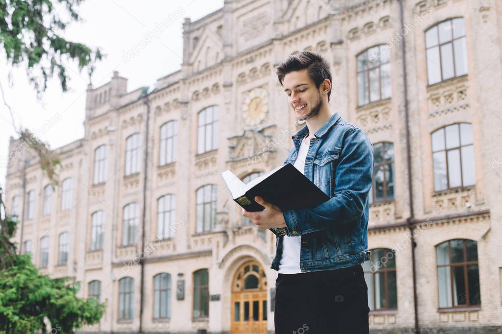 Successful happy students standing near campus or university outside