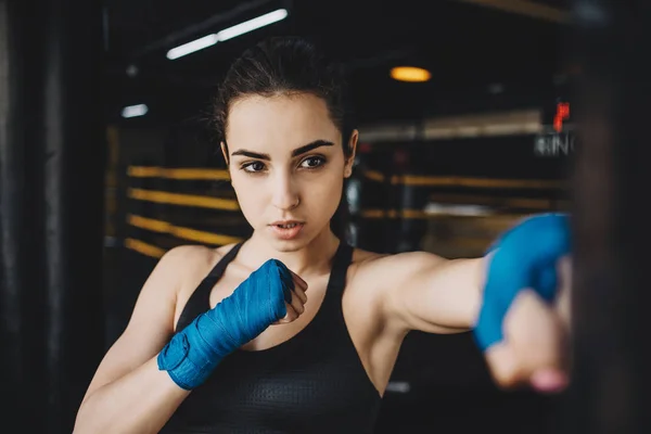 Beautiful and fit female fighter getting prepared for the fight or training