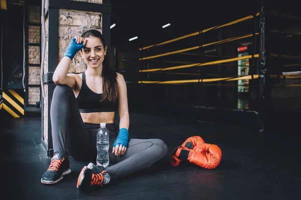 Beautiful and fit female fighter getting prepared for the fight or training