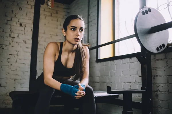 Mujer joven descansando un poco después del entrenamiento duro en el gimnasio . — Foto de Stock