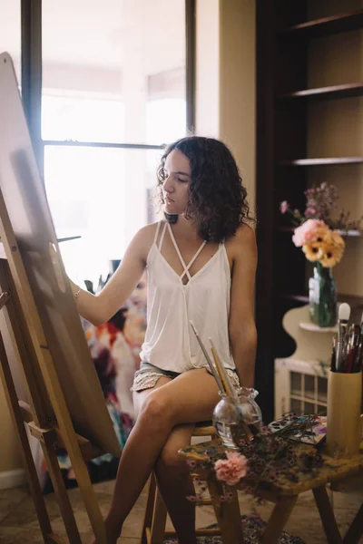 Artist girl paints picture on canvas in studio — Stock Photo, Image