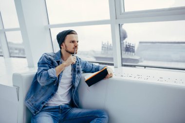 Adam kanepede oturan ve not yazma