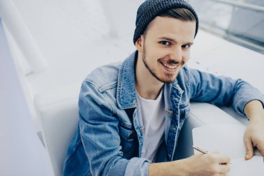 Adam kanepede oturan ve not yazma