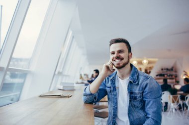 Adam tablo penceresi yakınındaki önünde oturuyor