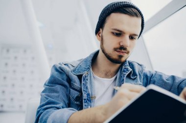 Adam kanepede oturan ve not yazma