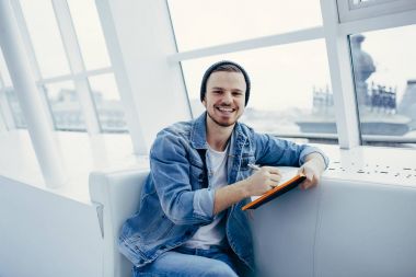 Adam kanepede oturan ve not yazma