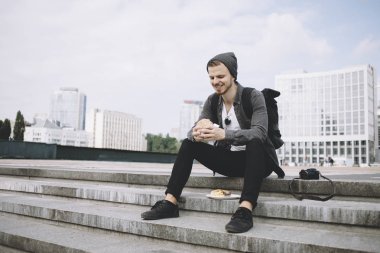 Gezgin sonra uzun yolculuk basamaklarında oturan ve burger onun elinde tutan