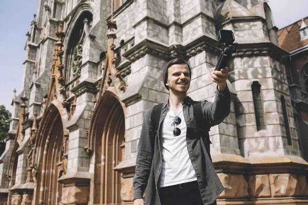 Счастливый путешественник делает селфи возле здания собора в городе — стоковое фото