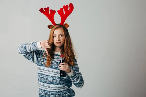 Rödhårig flicka vägrar dricka läsk vid jul för att inte skada sockret med sin hälsa. Tonåring med kronhjortshorn före nyår. Hon gillar inte saharadrinkar. Stockbild