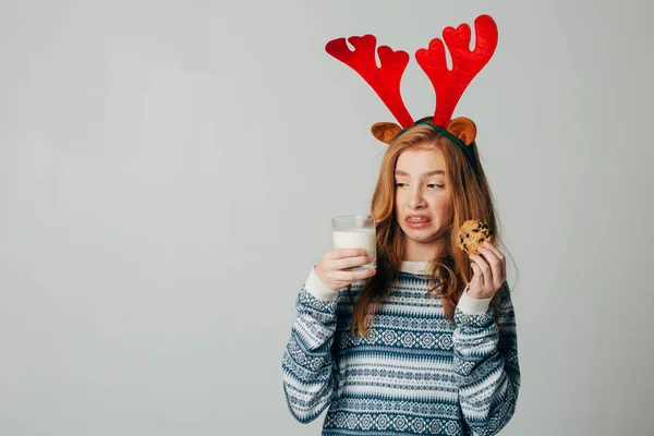 Рыжий подросток не любит молоко. У девочки непереносимость лактозы. Рождественские подарки для Санты Лицензионные Стоковые Изображения