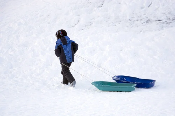 Boy with a sled in the snow Royalty Free Stock Photos