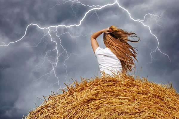 Dziewczyna na stogu siana podczas burzy i błyskawic Obrazy Stockowe bez tantiem