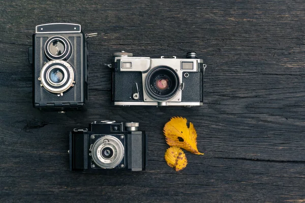 Old film camera on grunge dark wooden background