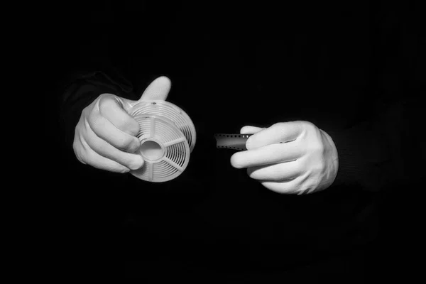 Laboratoire, les mains dans des gants blancs tiennent un noir et film, chambre noire, développeurs Images De Stock Libres De Droits
