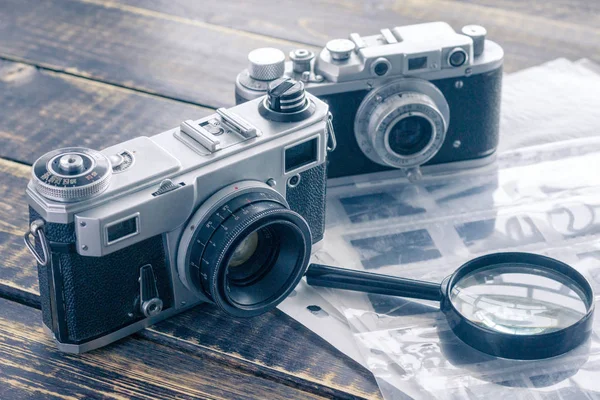 Två vintage filmkameror, en svartvit negativ film i den — Stockfoto