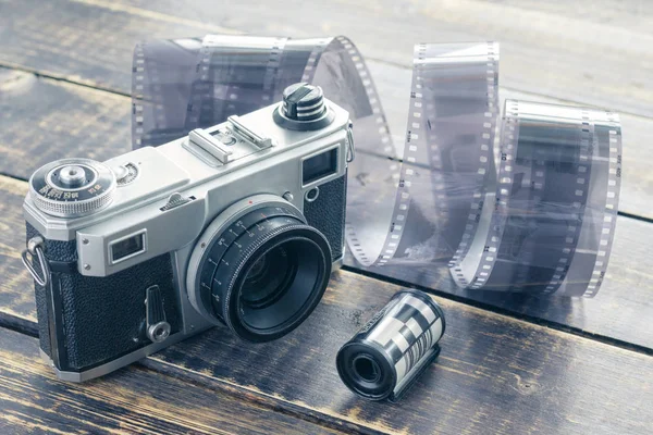 Oude filmcamera, zwart-wit film en filmrol op een houten — Stockfoto