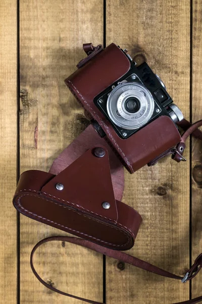 老式的模拟相机在一个棕色的皮革盒上的木 backgroun — 图库照片