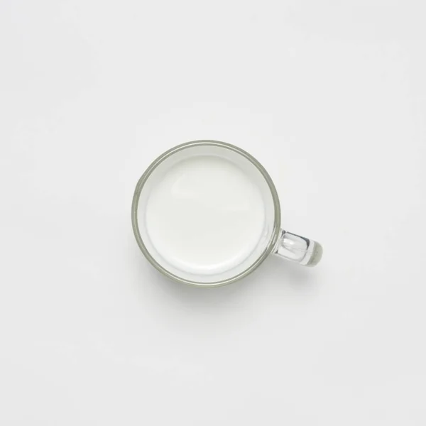 Tasse en verre avec du lait sur fond blanc — Photo