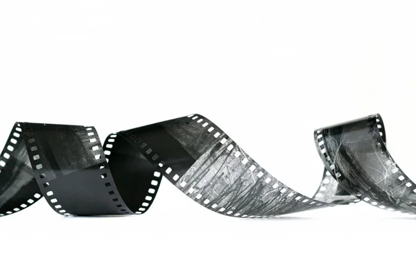 Espiral de filme negativo preto e branco sobre fundo branco — Fotografia de Stock