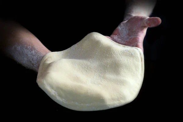 Pâte à pizza dans les mains d'un boulanger Images De Stock Libres De Droits