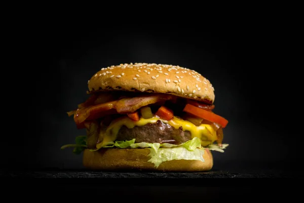 Primer plano de deliciosa hamburguesa fresca sobre un fondo oscuro. Hambu. —  Fotos de Stock