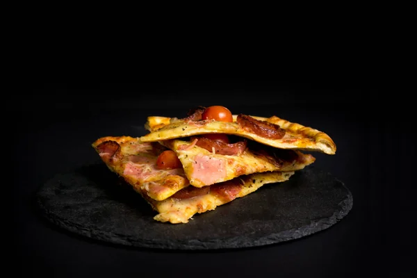 Tranches de pizza sur un fond noir avec une pile Images De Stock Libres De Droits