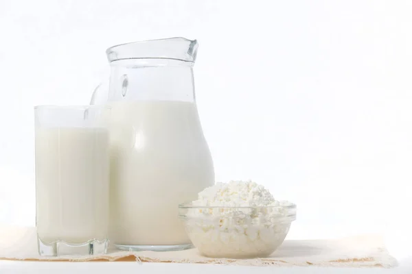 Productos lácteos, jarra y vaso con leche, tazón de requesón —  Fotos de Stock