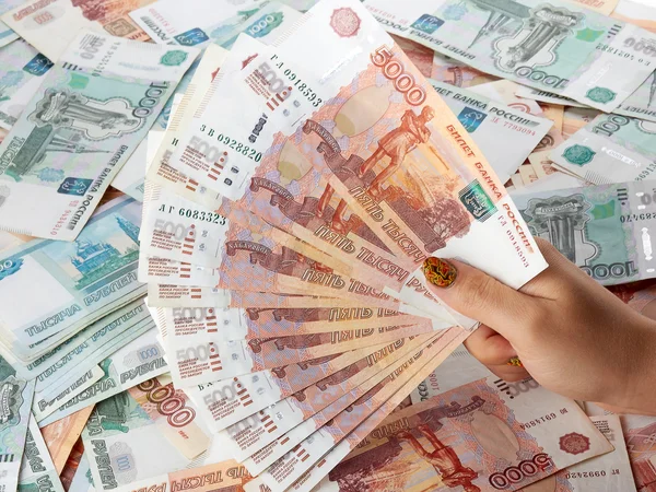 Vrouwelijke hand met een grote hoeveelheid geld van de Russische roebel. — Stockfoto