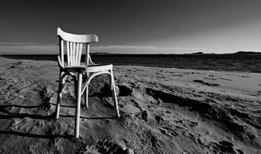 Kızıl Deniz kumlu bir plaj üzerinde boş bir eski beyaz sandalye