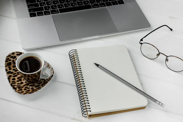 Beyaz ahşap bir masa üzerinde kalem ile iş planlayıcısı. Fincan espresso kahve ve defter ile yapmak için liste. İş toplantısı için hazırlanıyor. Bilgisayar gözlük ve laptop. Yalıtılmış çalışma araçları