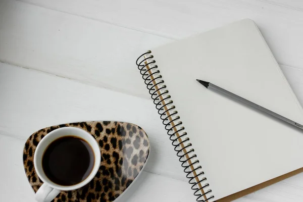 Beyaz ahşap bir masa üzerinde kalem ile iş planlayıcısı. Fincan espresso kahve ve defter ile yapmak için liste. İş toplantısı için hazırlanıyor. Bilgisayar gözlük ve laptop. Yalıtılmış çalışma araçları