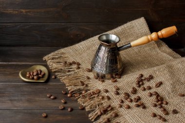 Vintage bakır kahve pod ahşap saplı bir tablo bileşimi, fasulye ve espresso kahverengi masa örtüsü üzerinde % 100 saf arabica kavrulmuş. Kahve severler için mükemmel sabah fikirler