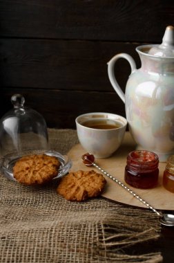 Ahşap tepsi üzerinde ev yapımı Berry üç küçük kavanoz reçel. Sağlıklı gıda fikirler. Çaydanlık ve yeşil çay bir arka plan üzerinde çay fincanı. Gül ahşap bir masa bir gümüş kaşık yanında bastırdı