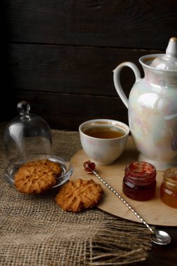 Ahşap tepsi üzerinde ev yapımı Berry üç küçük kavanoz reçel. Sağlıklı gıda fikirler. Çaydanlık ve yeşil çay bir arka plan üzerinde çay fincanı. Gül ahşap bir masa bir gümüş kaşık yanında bastırdı