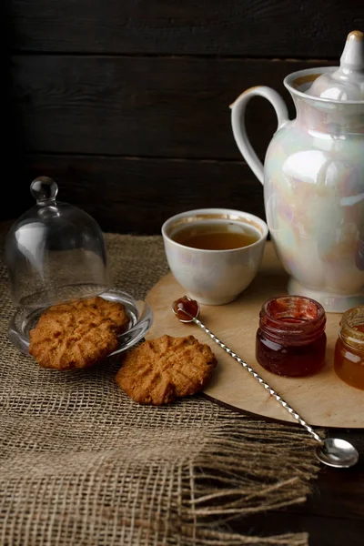 Ahşap tepsi üzerinde ev yapımı Berry üç küçük kavanoz reçel. Sağlıklı gıda fikirler. Çaydanlık ve yeşil çay bir arka plan üzerinde çay fincanı. Gül ahşap bir masa bir gümüş kaşık yanında bastırdı