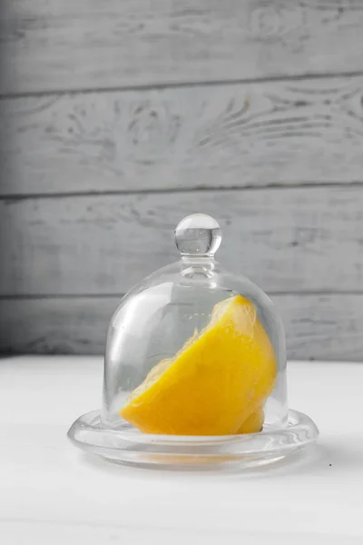Yarısı sarı limon bir cam daire üzerinde yalan. Ahşap masa arka planda. Sarı meyve kapatın. Sağlıklı yaşam tarzı ve taze meyve suyu