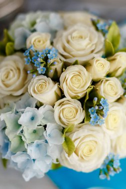 Nefis bahar buket. Mavi ve beyaz düğün çiçekleri. Düğün çiçek süslemeleri. Gök mavi bir vazo da kompozisyon. Güller, zambaklar ve menekşeler. Makro yakın çekim. Mükemmel kızı hediye fikri