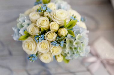 Nefis bahar buket. Mavi ve beyaz düğün çiçekleri. Düğün çiçek süslemeleri. Gök mavi bir vazo da kompozisyon. Güller, zambaklar ve menekşeler. Makro yakın çekim. Mükemmel kızı hediye fikri