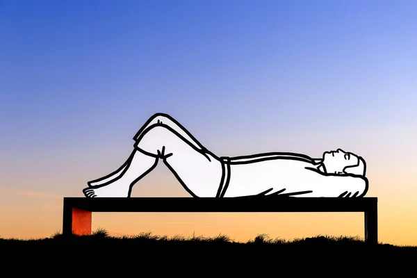 Лежащий человек на скамейке на закате — стоковое фото