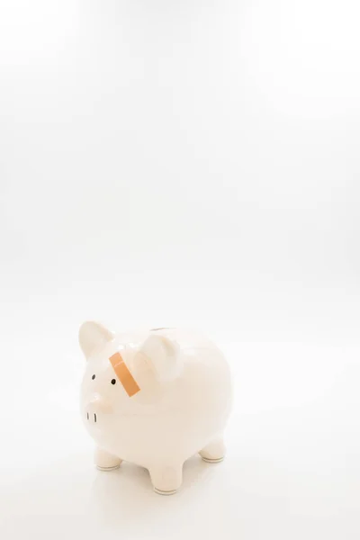 Piggy Bank moet helpen pleister op links gezicht — Stockfoto