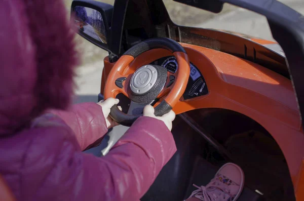 Hands on electric car steering wheel.