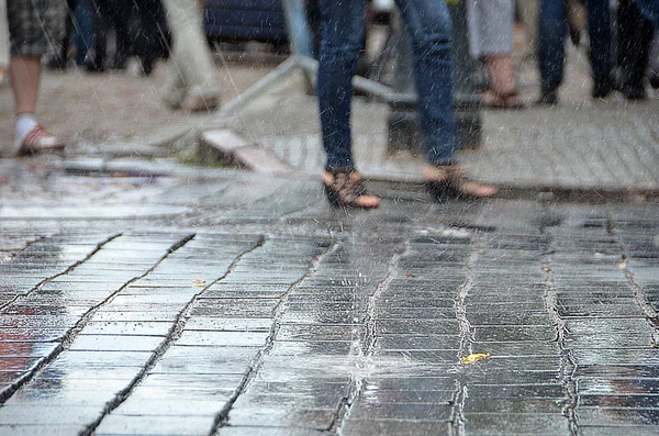 雨の路上の人々 が行く — ストック写真