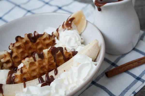 banana split with ice cream, chocolate, whipped cream and waffles.