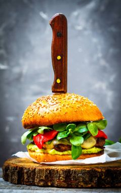 Lezzetli ızgara biftek burger peynir, guacamole ve biber turşusu.