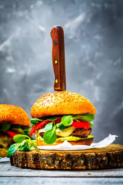 Sabrosa hamburguesa a la parrilla con queso, guacamole y pimientos en escabeche . —  Fotos de Stock