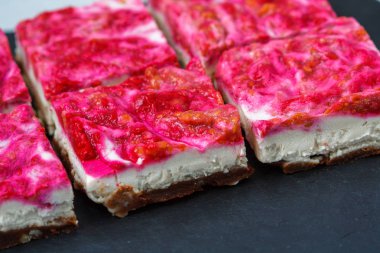 Vegan ham ahududu cheesecake karanlık bir arka plan üzerinde.