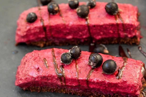 Raw chocolate berry cake with berries and chocolate syrup and currant.