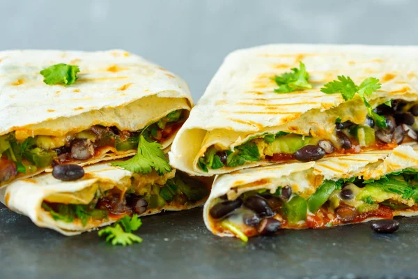 Burritos vegetarianos envolve feijão, abacate e queijo em uma ardósia — Fotografia de Stock